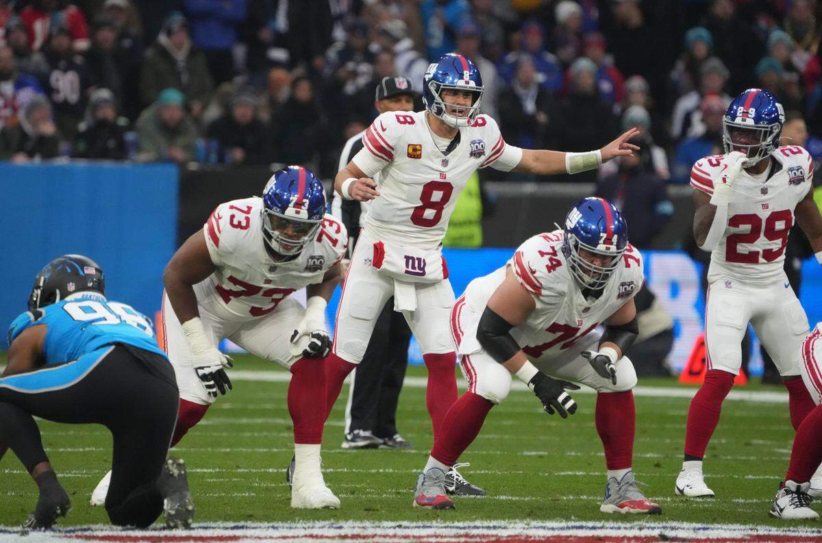 Nov 10, 2024; Munich, Germany; New York Giants quarterback Daniel Jones (8) prepares to take the snap against the Carolina Panthers in the first half during the 2024 NFL Munich Game at Allianz Arena. Mandatory Credit: Kirby Lee-Imagn Images