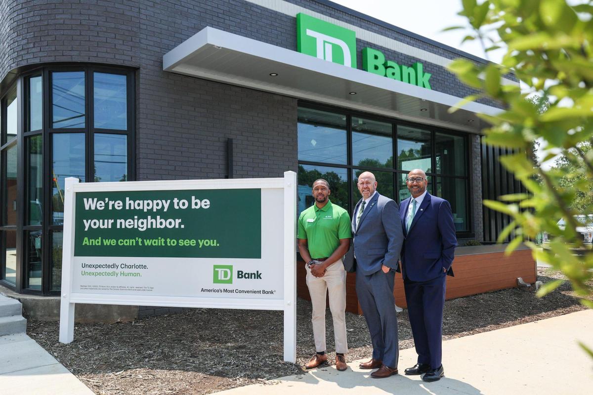 From left, Marcus Nelson, Jay Johnson and Hugh Allen stand in front of the soon to be open TD Bank on Beatties Ford Road.