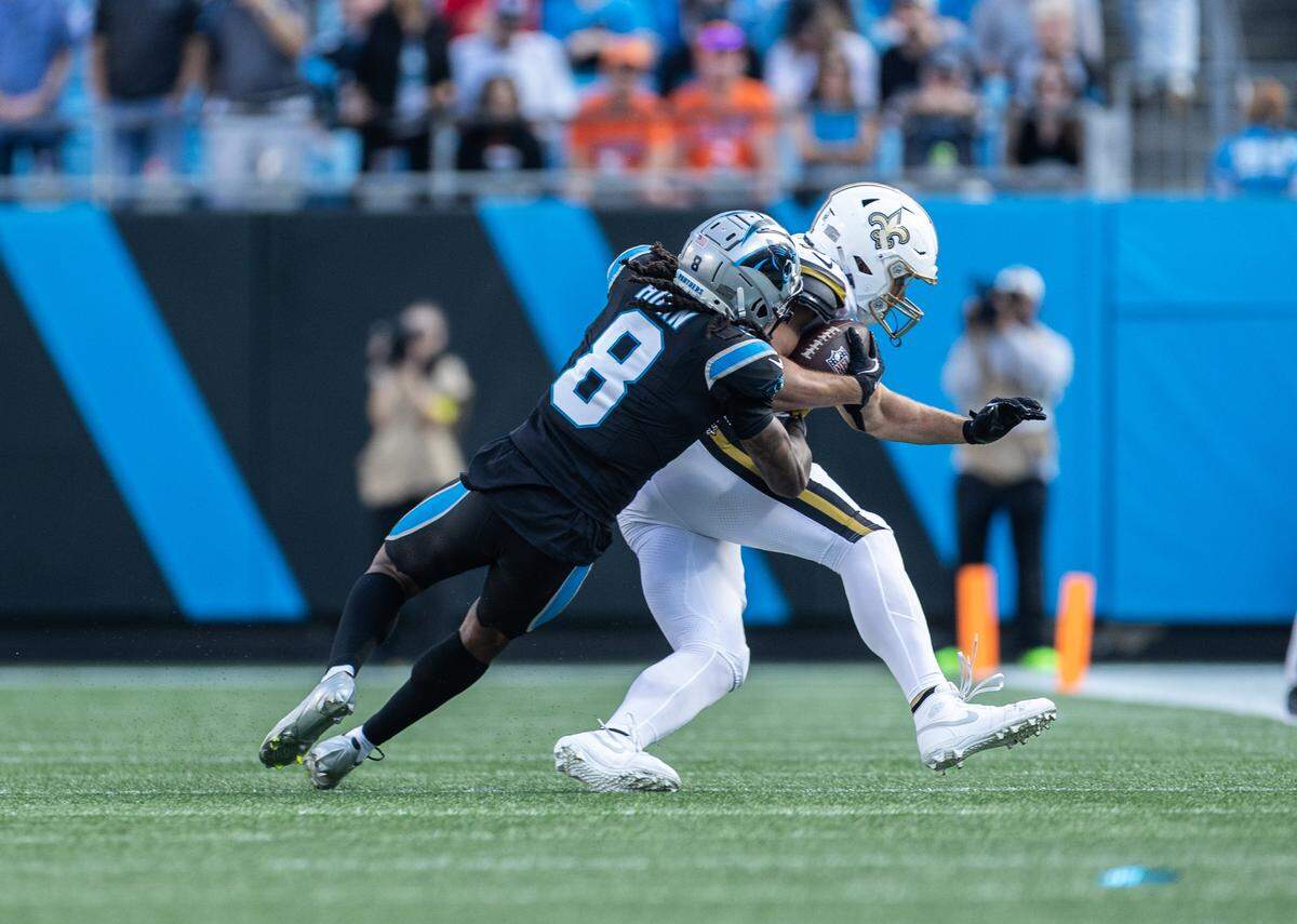 Carolina Panthers cornerback Jaycee Horn, left, tackles New Orleans Saints tight end Foster Moreau on Nov. 9.