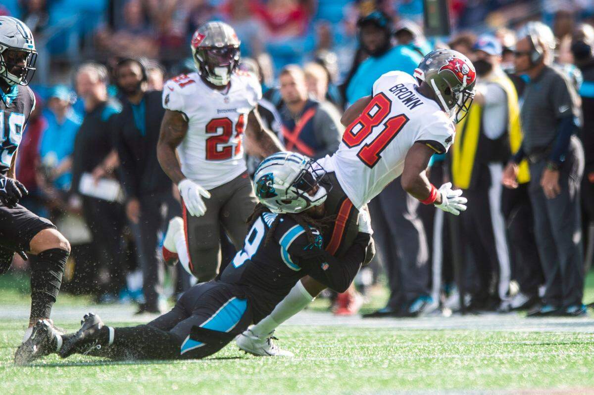 Panthers cornerback Stephon Gilmore, center, tries to stop the Buccaneers wide receiver Antonio Brown during the game at Bank of America Stadium on Sunday, December 26, 2021 in Charlotte, NC.
