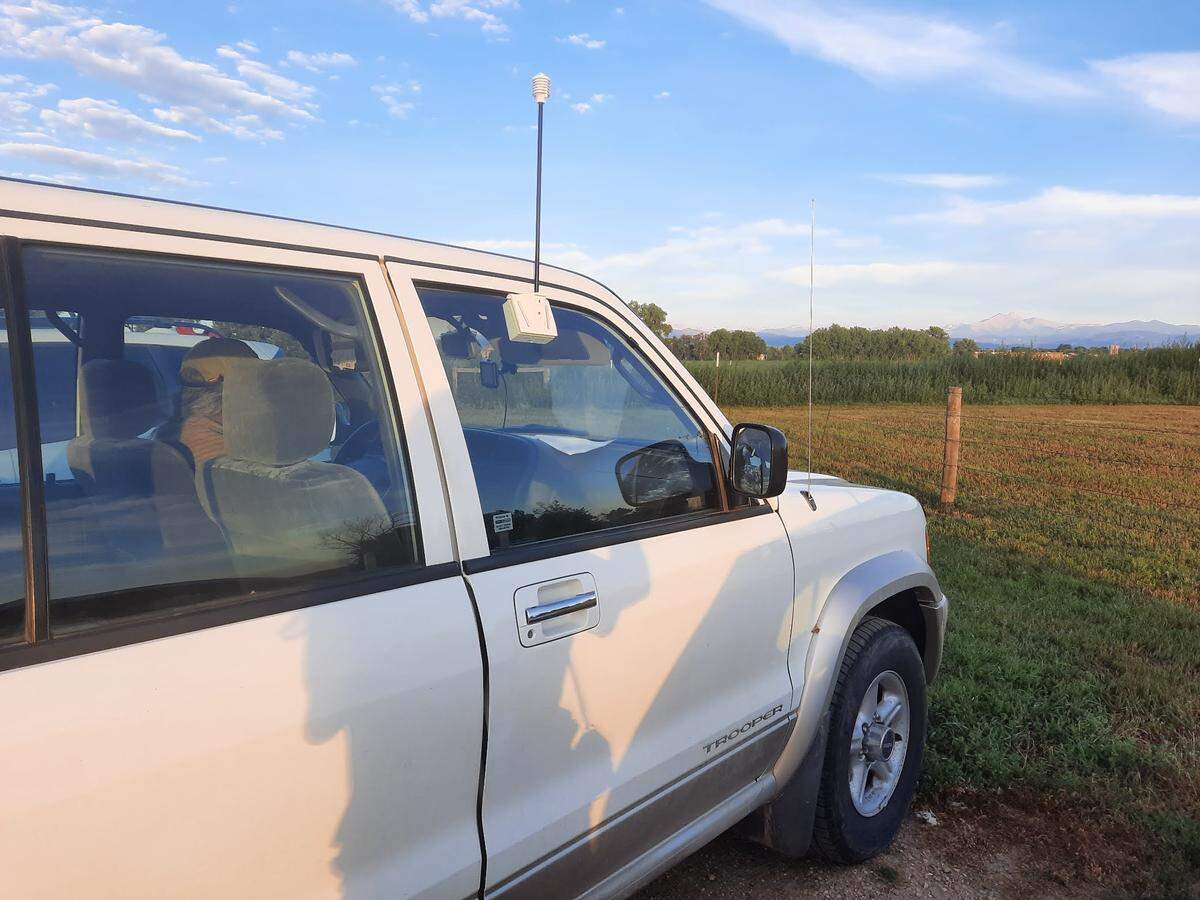 A heat mapping sensor hangs on the windshield of a white car in Longmont, Colorado. The sensors are used to track the temperatures of different neighborhoods.