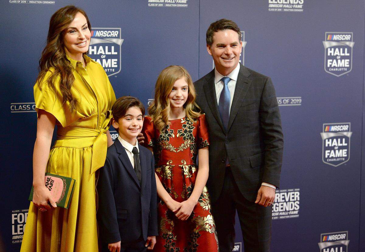 Former NASCAR driver Jeff Gordon, right, smiles for photographers with his wife, Ingrid Vandebosch-Gordon (left) and their children, Leo and Ella Sofia, in February 2019 before Gordon was inducted into NASCAR’s Hall of Fame.