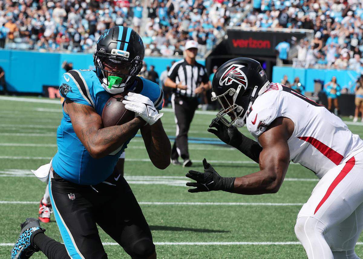 Carolina Panthers' Ja'Tavion Sanders carries the ball as Atlanta Falcons' Divine Deablo tries to block him at the Bank of America Stadium in Charlotte on Sunday, September 21, 2025.