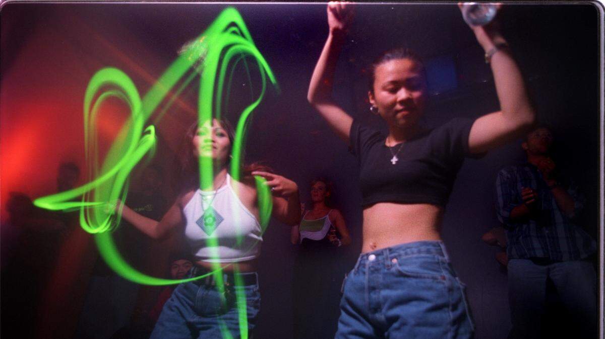 Khio Senensom, left, dances with a glow stick with her friend Lil Lee late night as DJ Andy K spins his house music at Mythos dance club.