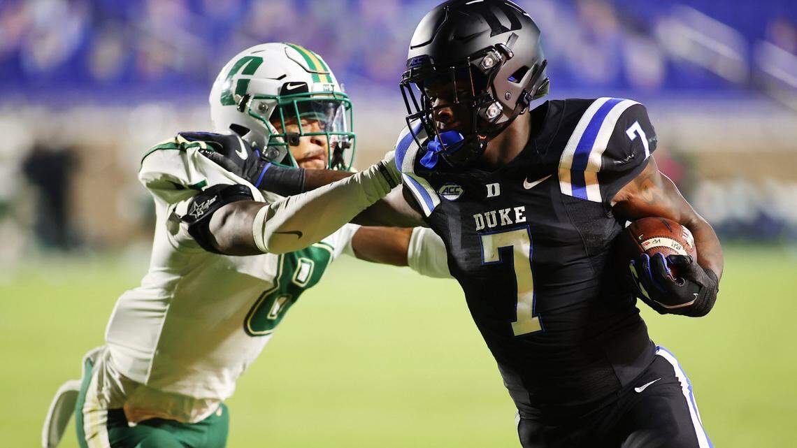 Duke running back Jordan Waters (7) scores a touchdown while Charlotte 49ers defensive back Nafees Lyon (8) tries to stop him.