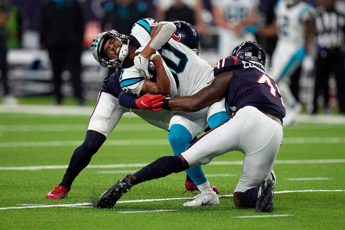 Carolina Panthers running back Chuba Hubbard, center, is tackled by Houston Texans’ Zach Cunningham (41) and Desmond King II during the first half of an NFL football game Thursday, Sept. 23, 2021, in Houston.