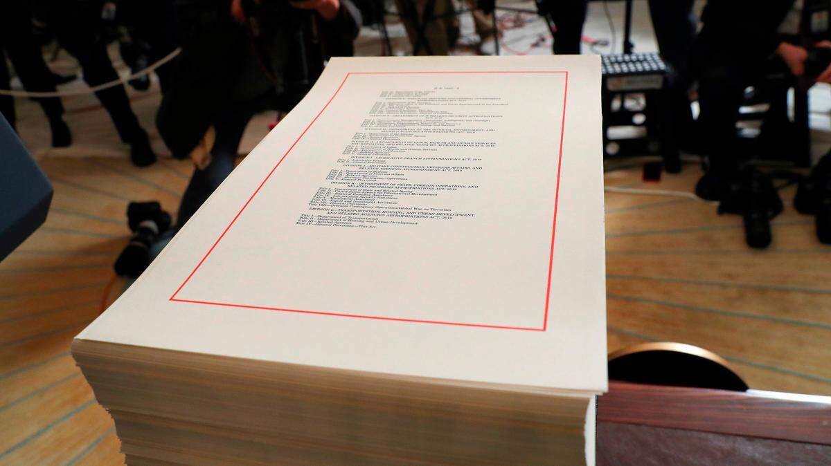 A copy of the $1.3 trillion spending bill is stacked in the White House. Republican tax cuts are helping drive the annual budget deficit over $1 trillion.