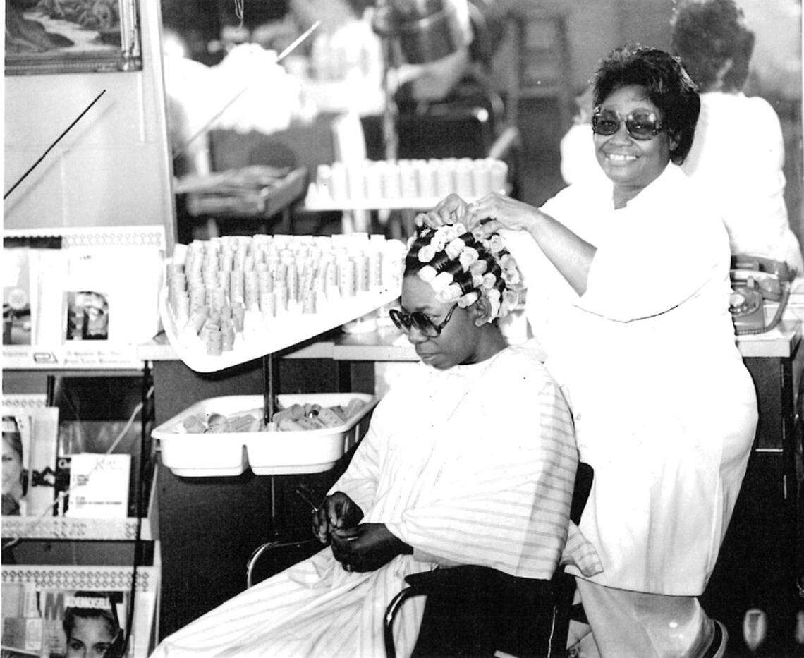 Catherine Simmons, right, does a woman’s hair in the salon that she owned near Beatties Ford Road and LaSalle Street. Simmons opened the salon in 1959.