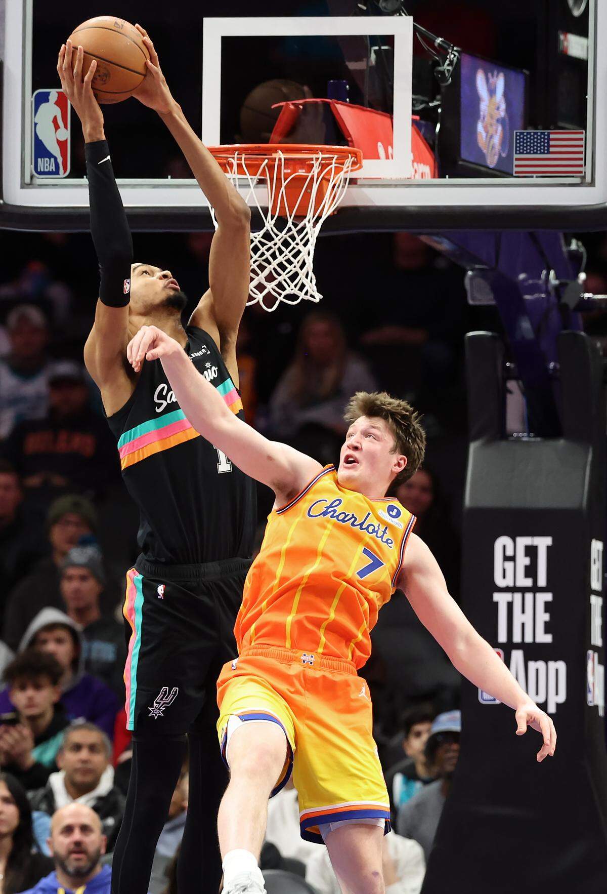 San Antonio Spurs center Victor Wembanyama, left, throws down a two-handed dunk over Charlotte Hornets forward Kon Knueppel, right, during Saturday’s action at Spectrum Center.