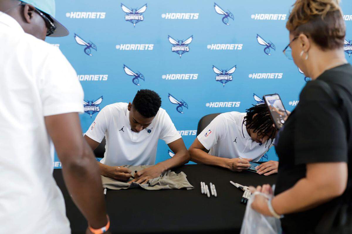 Newly Drafted players Brandon Miller, left, and Amari Bailey sign autographs for fans after a press conference with the players at Spectrum Center on Friday, June 23, 2023.