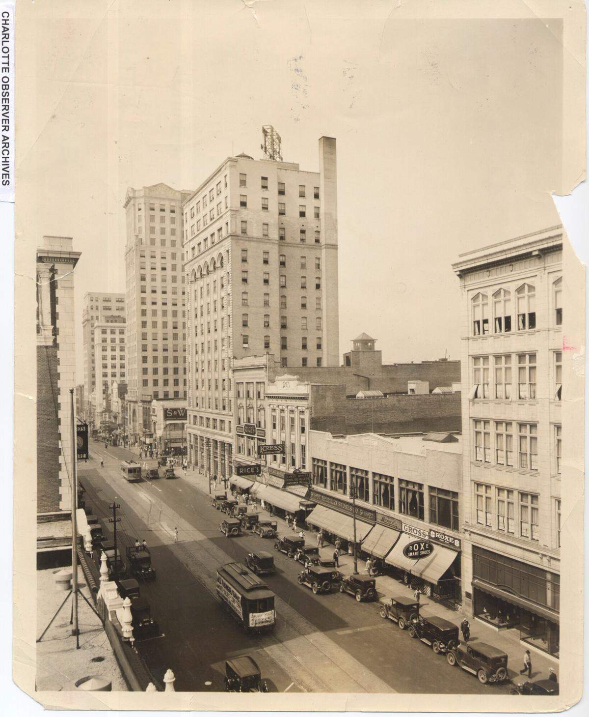 View of North Tryon St., looking south towards Square and beyond. The Independence building (center) was built in 1908. The 12-story building was noted in newspaper articles as the first steel frame tower built in North Carolina. In September 1981, the building was imploded after it was sold to developer Henry Faison, according to the Historic Landmarks Commission.