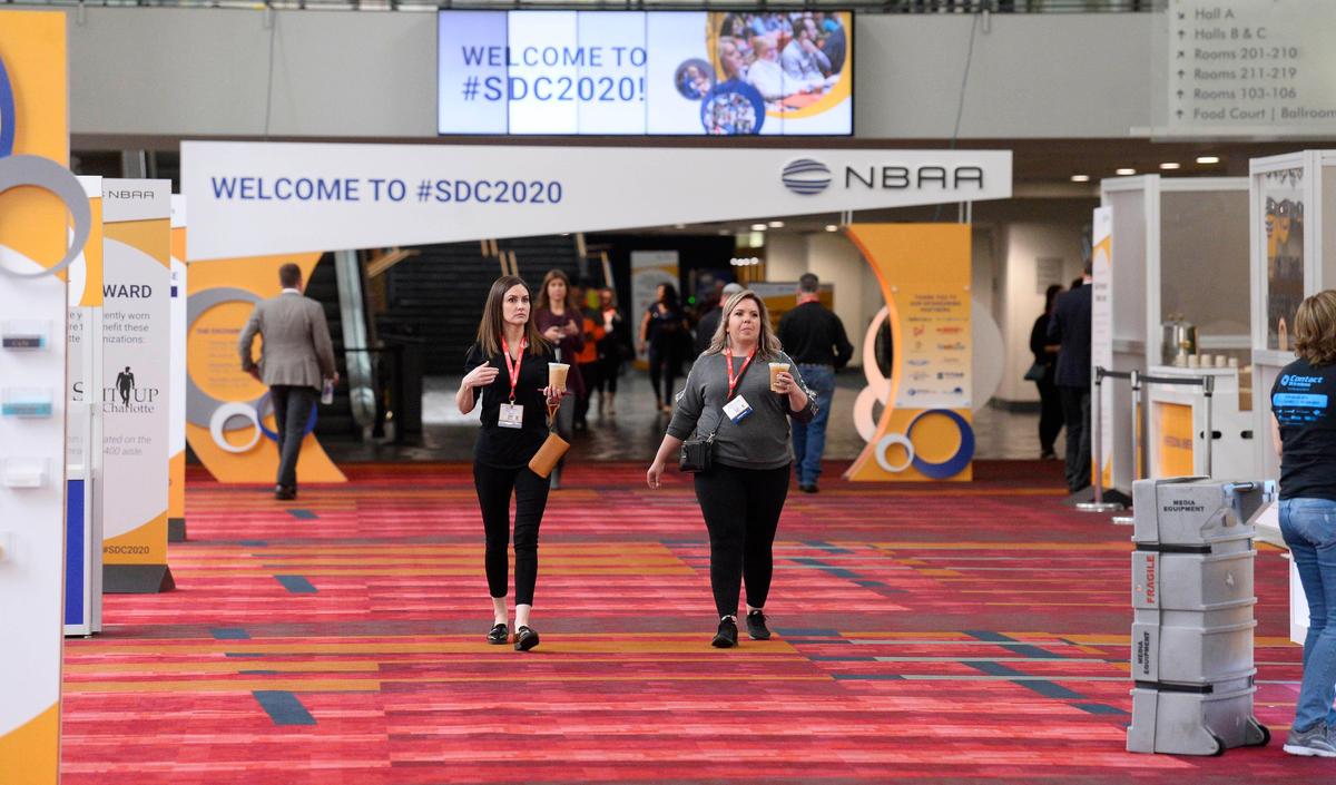 Convention attendees of the NBAA 2020 Schedulers & Dispatchers Conference (SDC2020) walk near the registration desk at the Charlotte Convention Center on Tuesday, March 10, 2020. Conventions across the nation are being cancelled or rescheduled in wake of spreading novel coronavirus.