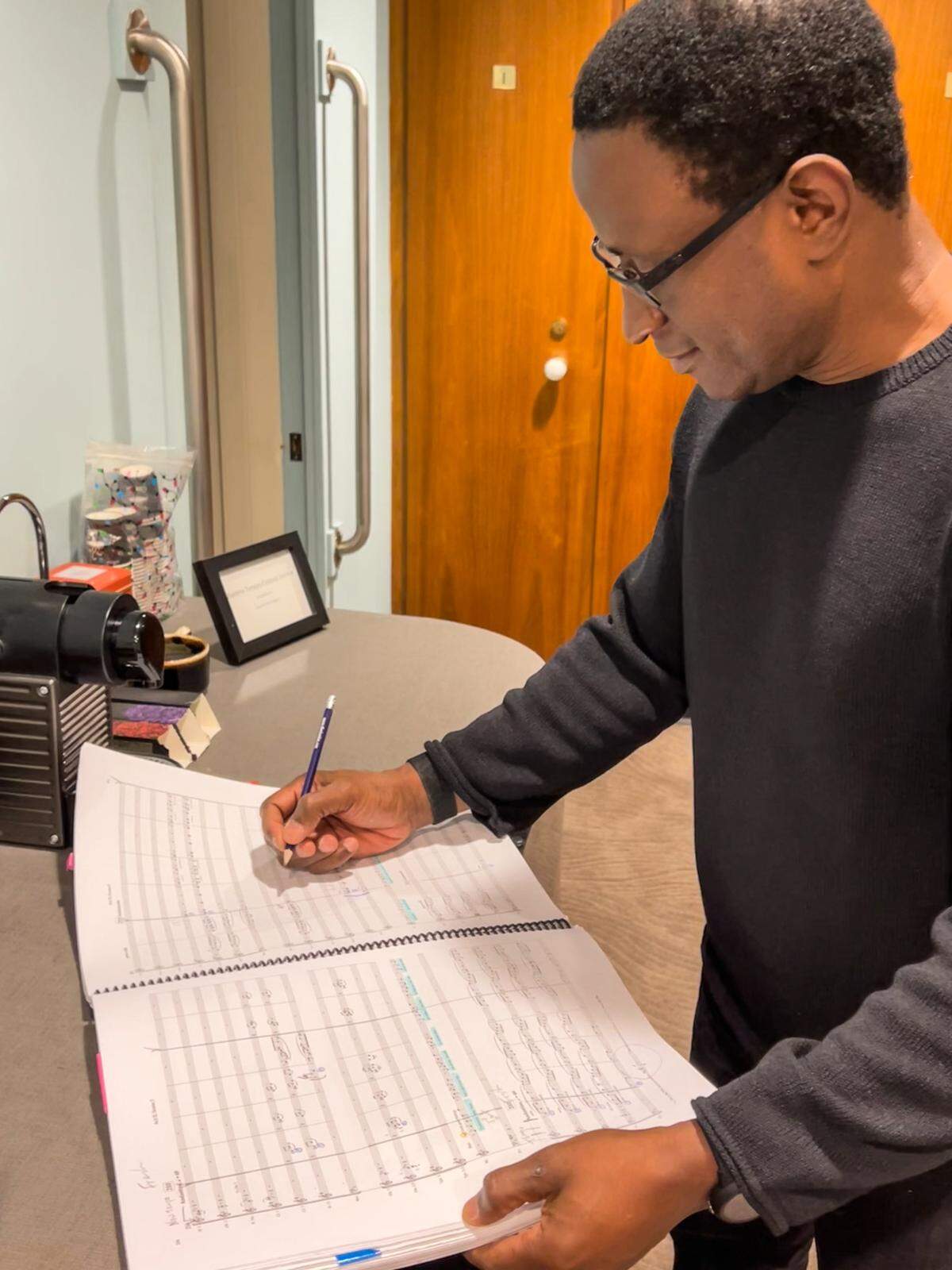 Kwamé Ryan looks over the three-volume score of “Porgy and Bess” backstage on Jan. 24, 2026, in his dressing room at the Met Opera in Lincoln Center, New York City.