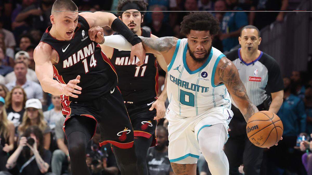 Charlotte Hornets forward Miles Bridges, right, uses his right arm to push Miami Heat guard Tyler Herro, left, away on a drive down the court at Spectrum Center on April 14.
