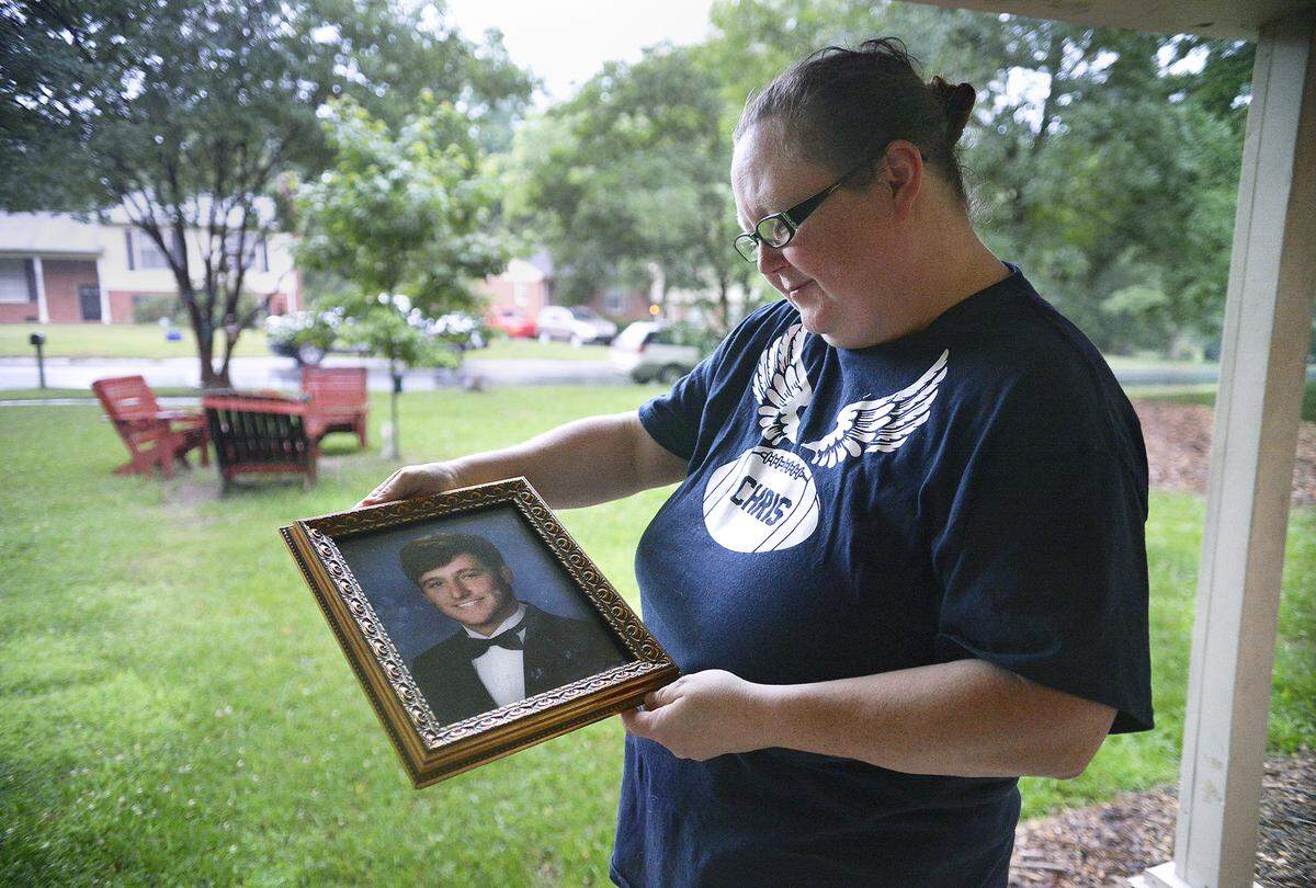 Beth Allen holds a photograph of her late son, Christian, who was shot to death at a party in 2017.