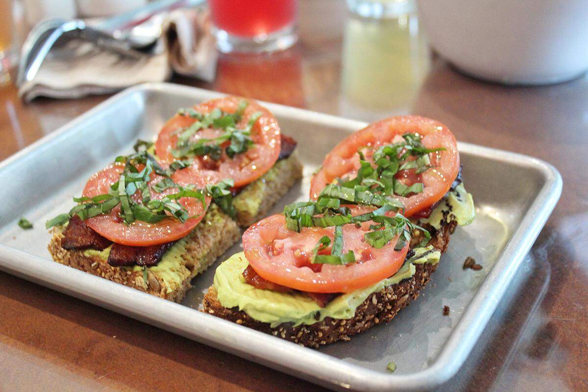 Add bacon to your avocado toast for the ultimate breakfast at Village Juice Co.