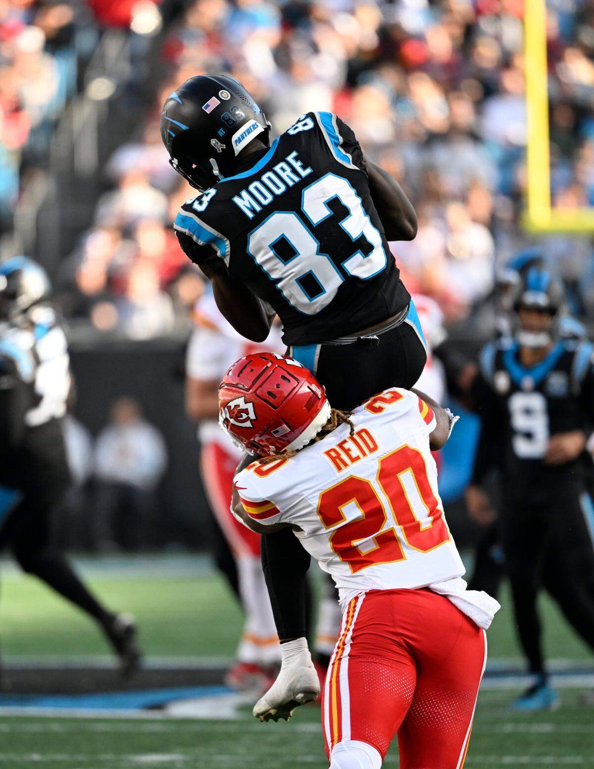 Nov 24, 2024; Charlotte, North Carolina, USA;  Carolina Panthers wide receiver David Moore (83) catches the ball as Kansas City Chiefs safety Justin Reid (20) defends in the third quarter at Bank of America Stadium. Mandatory Credit: Bob Donnan-Imagn Images