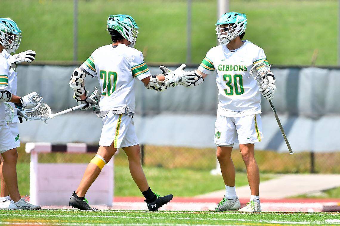 Cardinal Gibbons’ Brown Parker (20) congratulates Zach Kerner (30) on his goal against Lake Norman during the first half. The Lake Norman Wildcats and the Cardinal Gibbons Crusaders met in the Boys NCHSAA 4A Lacrosse Championship Game in Durham, N.C. on May 31, 2025.