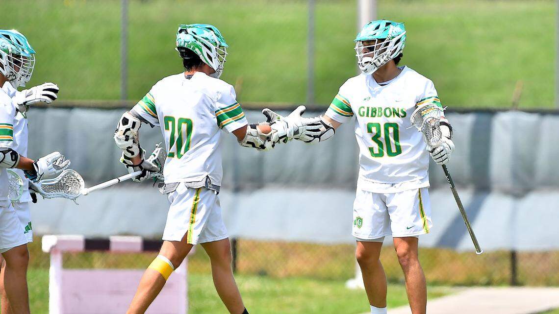 Cardinal Gibbons’ Brown Parker (20) congratulates Zach Kerner (30) on his goal against Lake Norman during the first half. The Lake Norman Wildcats and the Cardinal Gibbons Crusaders met in the Boys NCHSAA 4A Lacrosse Championship Game in Durham, N.C. on May 31, 2025.