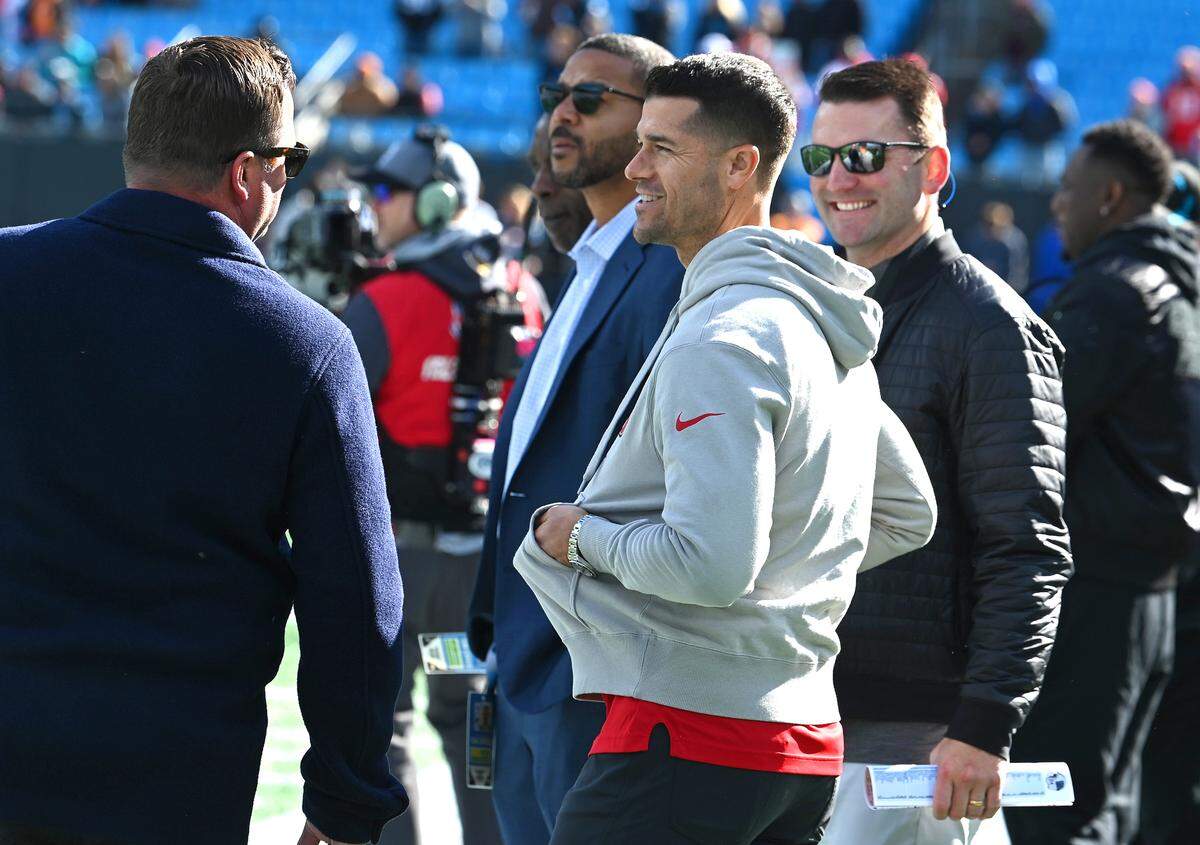 Carolina Panthers general manager Scott Fitterer, left, speaks with Tampa Bay Buccaneers offensive coordinator Dave Canales, center, along the Panthers sideline prior to the team’s game at Bank of America Stadium on Sunday, January 7, 2024 in Charlotte, NC. The Buccaneers defeated the Panthers 9-0. Later that month, Fitterer was fired and Canales became the Panthers’ head coach.