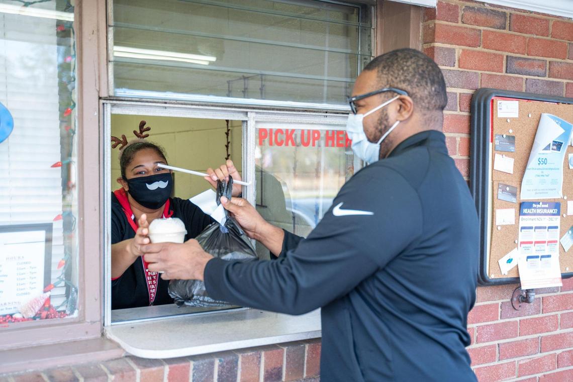 Derita Dairy Bar on West Sugar Creek Road has milkshakes and ice cream to to go with its sandwich, burger and hot dogs. Here, owner Devin McDaniel gives Steven Copeland his takeout order at the walk-up window.
