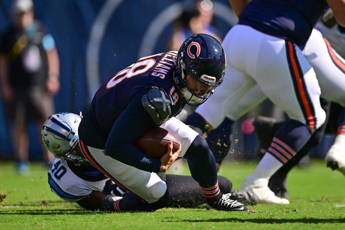 Oct 6, 2024; Chicago, Illinois, USA; Chicago Bears quarterback Caleb Williams (18) is sacked by Carolina Panthers defensive end Charles Harris (40) during the first quarter at Soldier Field. Mandatory Credit: Daniel Bartel-Imagn Images