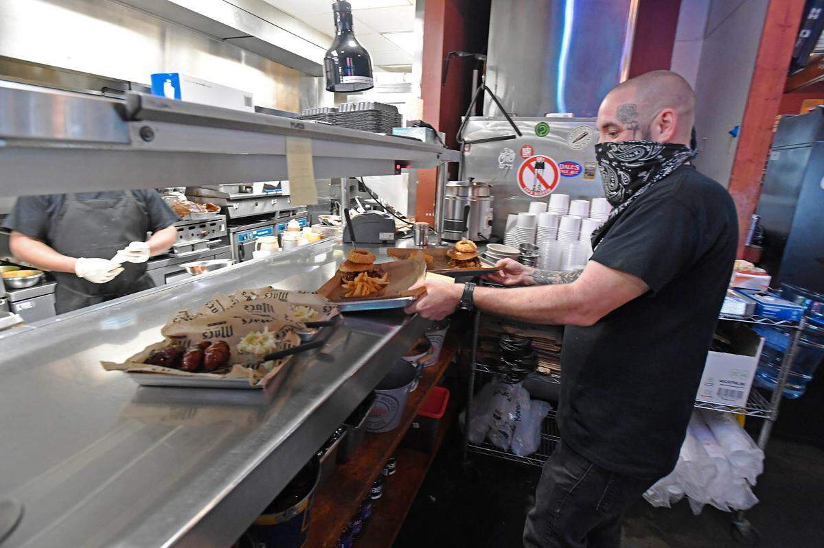 Chris Ogden prepares to serve orders to customers March 15 at Mac’s Speed Shop on South Boulevard. Mac’s Hospitality Group has seen business growth despite the coronavirus pandemic thanks to delivery and takeout, patio seating , social media marketing and community support.