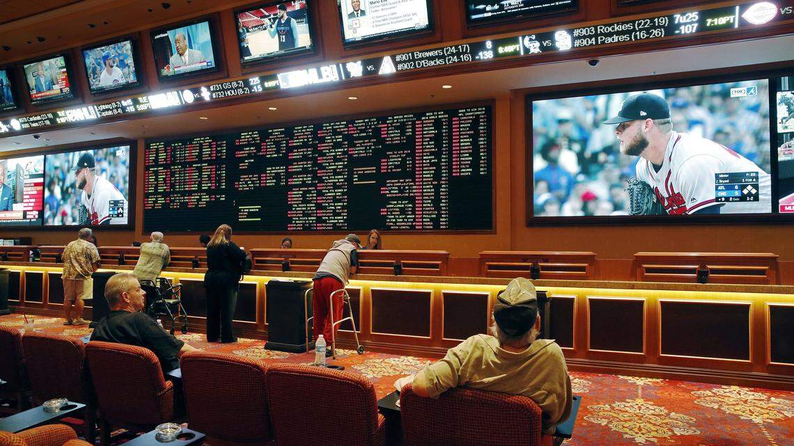 In this Monday, May 14, 2018 file photo, people make bets in the sports book at the South Point hotel and casino in Las Vegas. (AP Photo/John Locher)