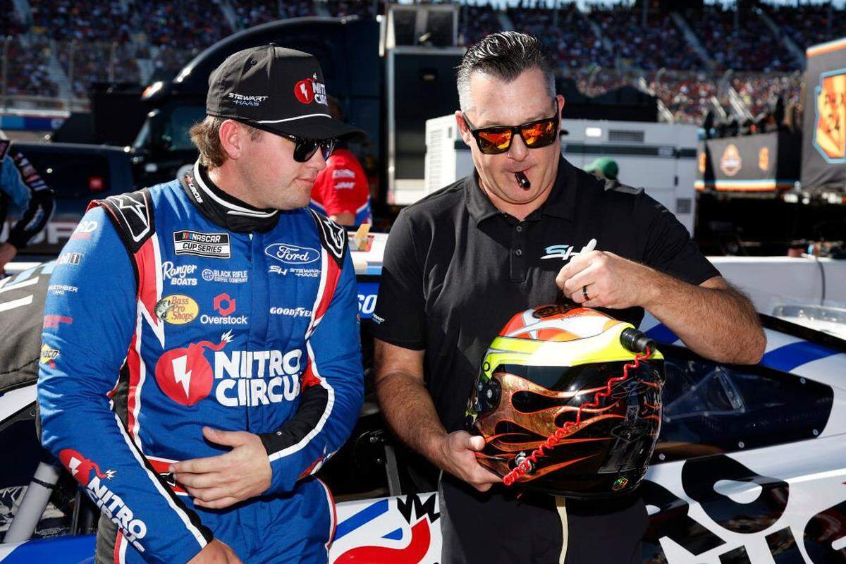Stewart-Haas Racing co-owner Tony Stewart, right, signs the helmet of Noah Gragson, driver of the #10 Nitro Circus Ford, on the grid prior to the NASCAR Cup Series Championship Race at Phoenix Raceway on Nov. 10, 2024 in Avondale, Arizona.