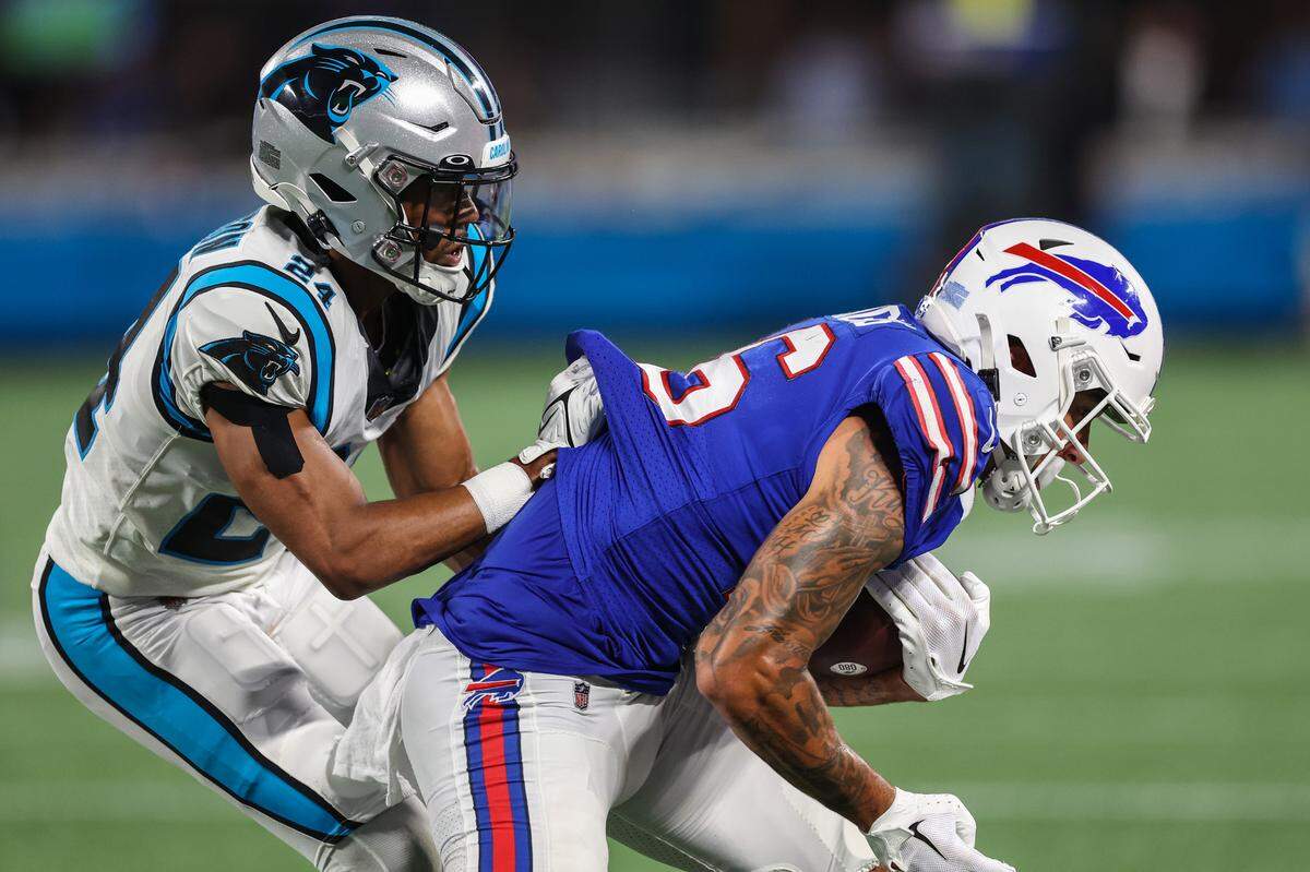Panthers cornerback CJ Henderson, left, grabs onto the jersey of Bills wide receiver Isaiah Hodgins during the game at Bank of America Stadium on Friday, August 26, 2022 in Charlotte, NC.