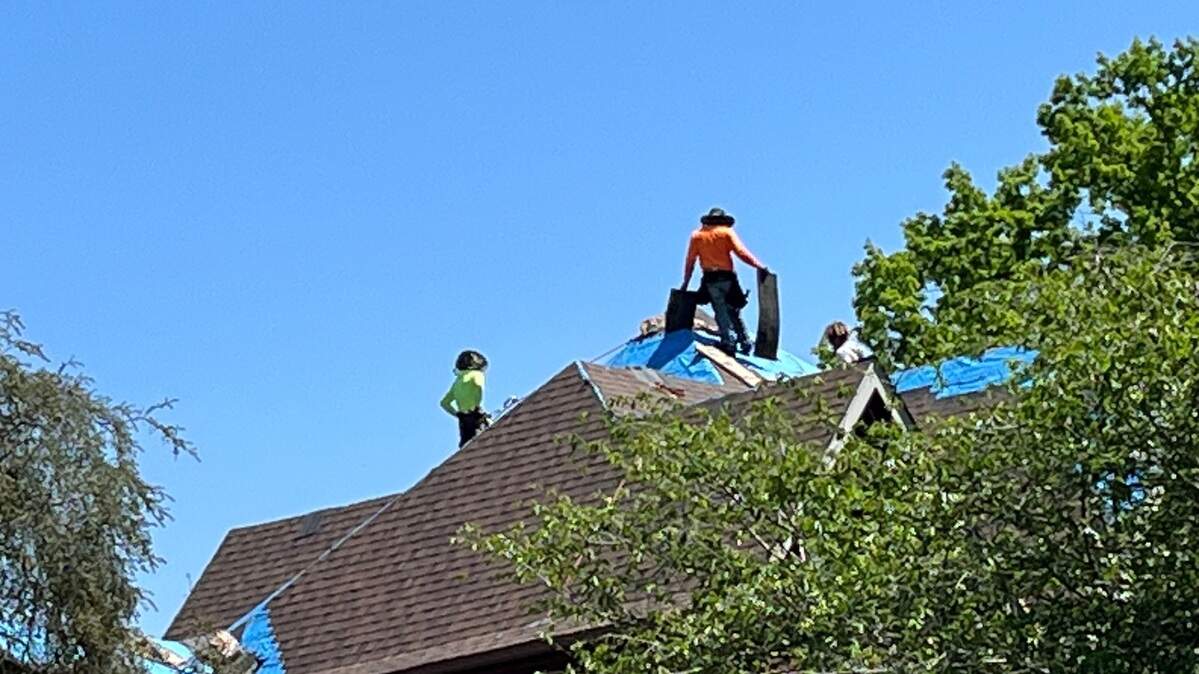 Workers repair a steep roof on a south Charlotte home.