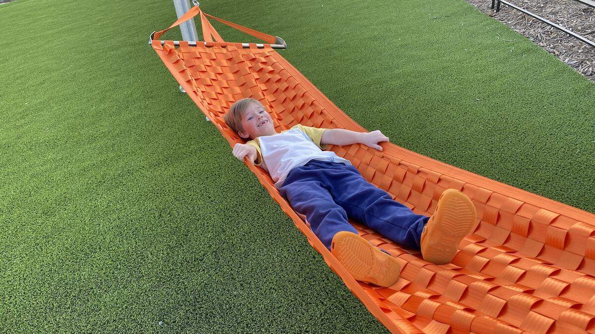 After an hour of climbing, running and playing, Evan Greene takes a rest in one of the hammocks at Stream Park in Ballantyne.