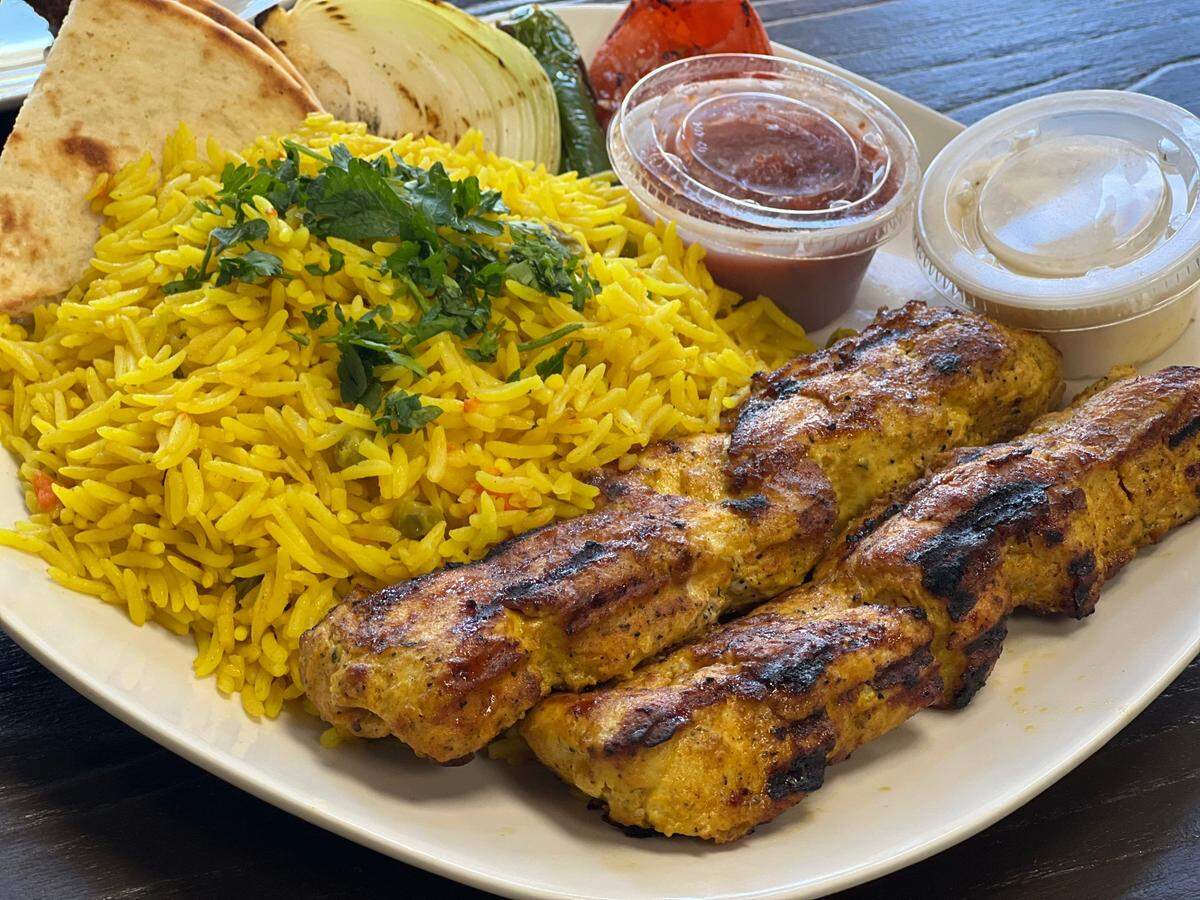 US Fried Chicken’s chicken kebab with yellow rice comes with pita, garlic white sauce and a Mediterranean-style tomato sauce.