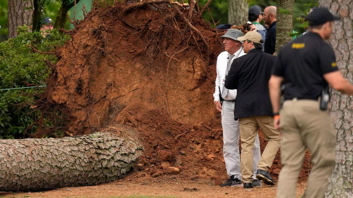 Volunteers and staff secure the area around where a tree fell near the 17th tee during the second round of The Masters golf tournament. 