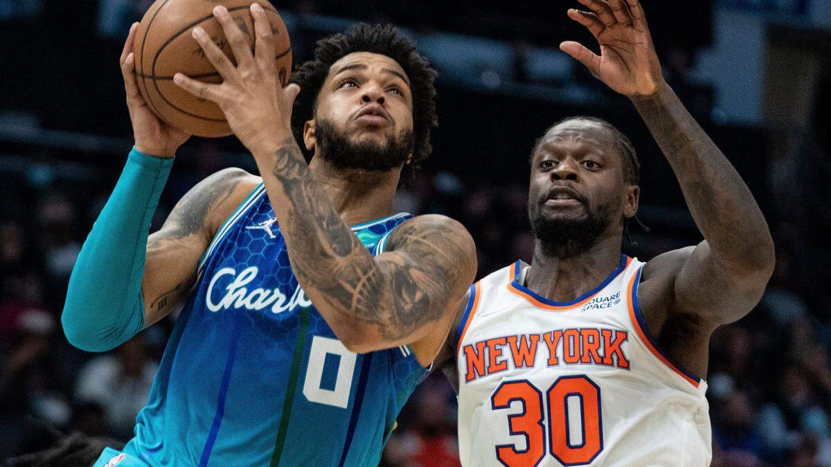 Charlotte Hornets forward Miles Bridges (0) drives to the basket past New York Knicks forward Julius Randle (30) during the first half of an NBA basketball game in Charlotte, N.C., Friday, Nov. 12, 2021. (AP Photo/Jacob Kupferman)