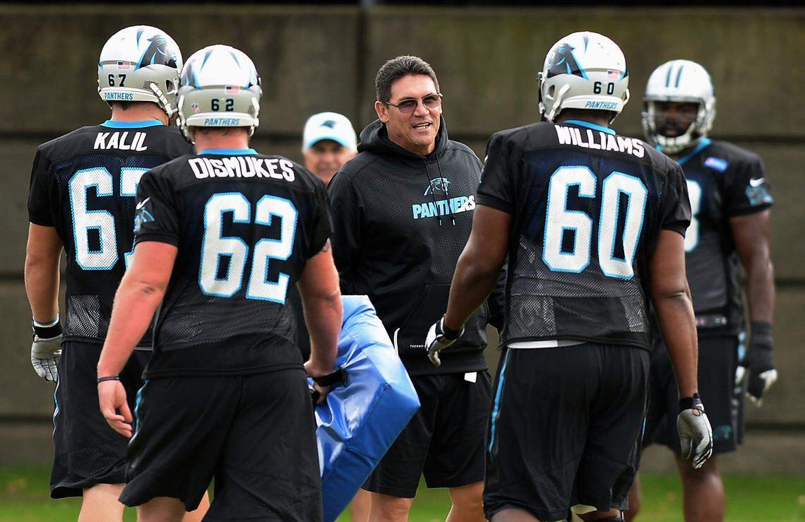 Coach Ron Rivera smiles as he talks with players during a midseason practice in Charlotte.