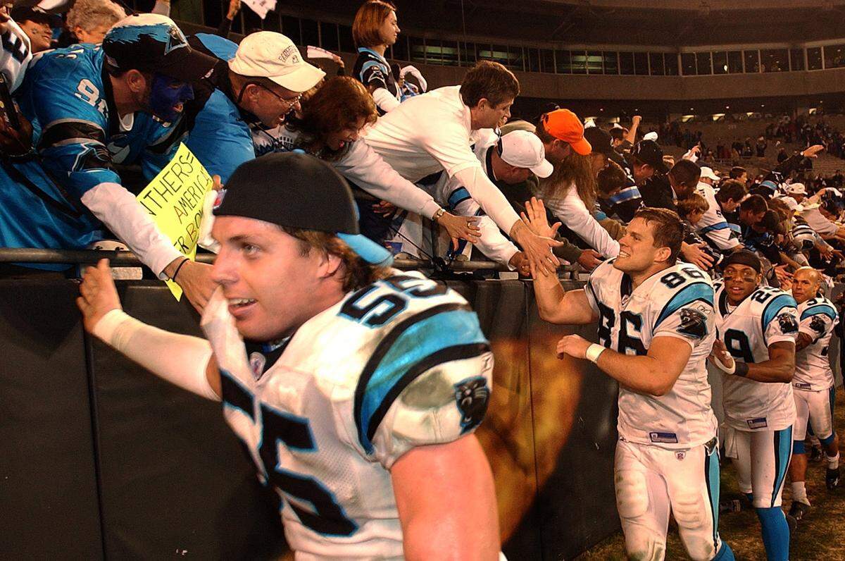 Carolina Panthers linebacker Dan Morgan slaps hands with the fans followed by his teammates following the team's playoff victory over the Dallas Cowboys on Jan. 3, 2004. Morgan would go on to eventually become the Panthers general manager after his playing career ended.