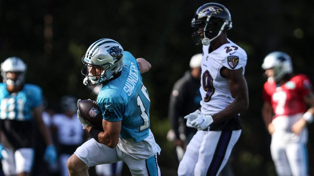 Carolina Panthers running back C.J. Saunders, left, runs past Baltimore Ravens defender Shaun Wade during a joint practice in Spartanburg, S.C., on Wednesday.