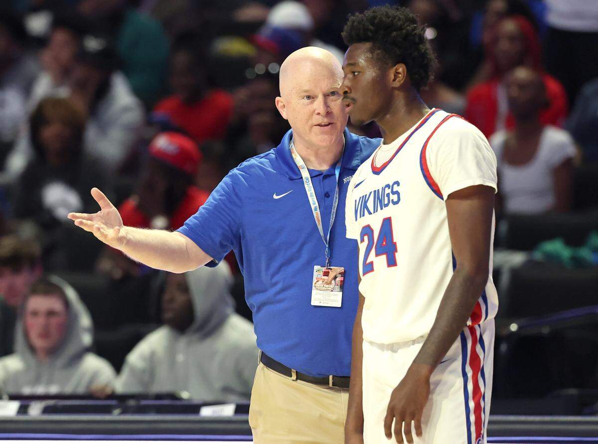 North Meck Vikings head coach Duane Lewis, left, talks with Kyle Matthews, right, during second-half action against Julius Chambers High in the 2025 West Regional Championship game at Lawrence Joel Veterans Memorial Coliseum in Winston-Salem. North Meck defeated Chambers 64-56.
