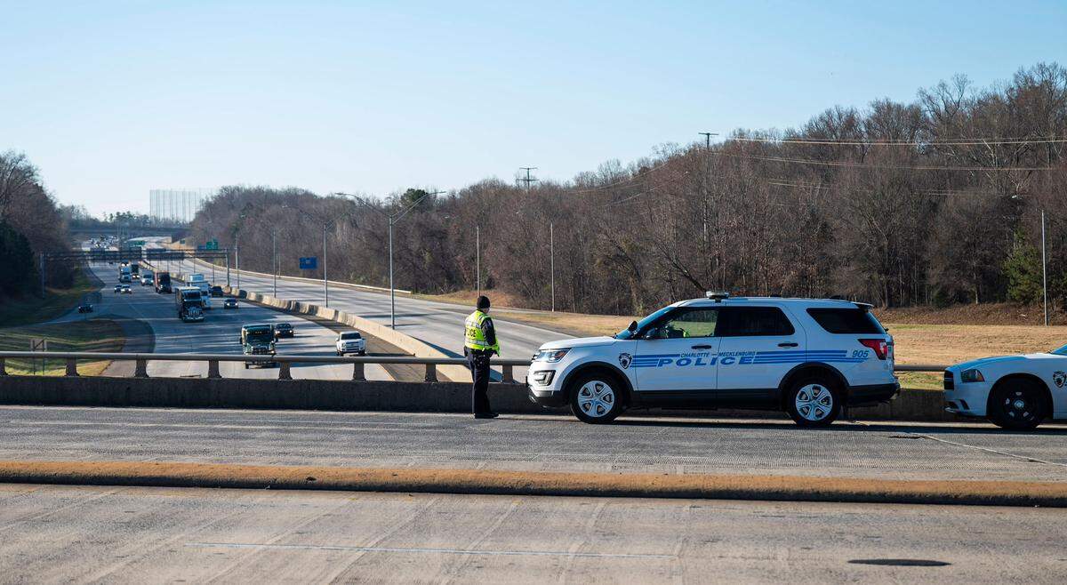 A Charlotte-Mecklenburg police officer monitors traffic from an overpass above Interstate 85 in northeast Charlotte on Wednesday, Dec. 22, 2021. A crash in the southbound lanes of I-85 near the WT Harris Boulevard exit killed police Officer Mia Goodwin and injured three others.