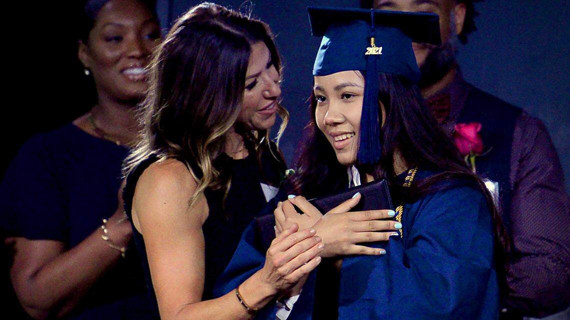 MC Hildreth, founder and head of school of The Nest Academy, left, embraces 2020 graduate Emily Adrong, right, during graduation exercises on Friday, June 4, 2021. The Nest Academy is a tiny school on Charlotte’s East side that is primarily for refugee and immigrant students. Friday the school graduated three students two from this year’s class and Adrong who did not have a ceremony last year due to COVID-19.