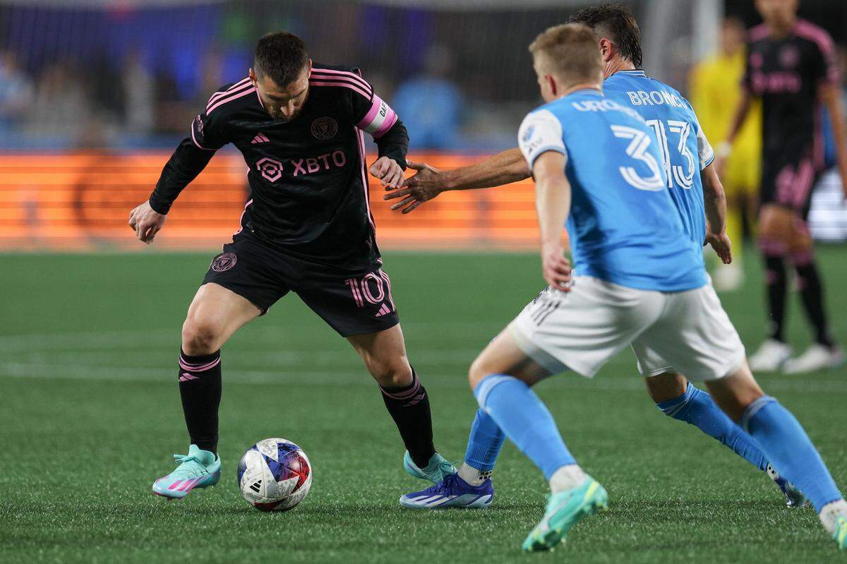 Inter Miami forward Lionel Messi, left, dribbles the ball as he tries to evade Charlotte FC’s defense at Bank of America Stadium on Saturday, October 21, 2023 in Charlotte, NC.