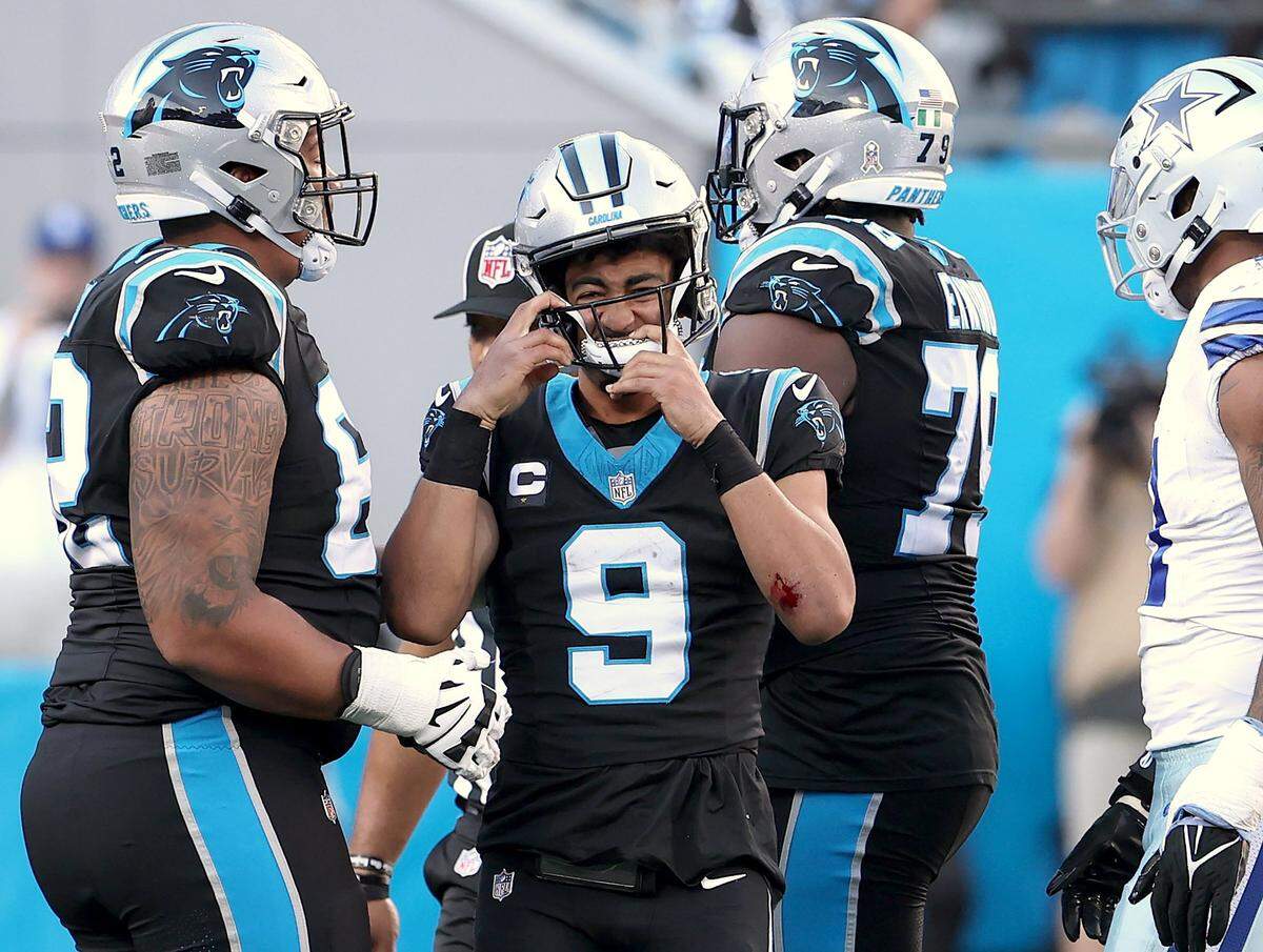 Carolina Panthers quarterback Bryce Young adjusts his helmet after being tackled by a Dallas Cowboys defender at Bank of America Stadium in Charlotte, NC on Sunday, November 19, 2023. The Cowboys defeated the Panthers 33-10.