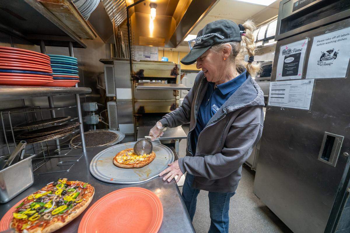 General manager Kea Hrvatin slices a 10” pizza at Wolfman Pizza in Cotswold.
