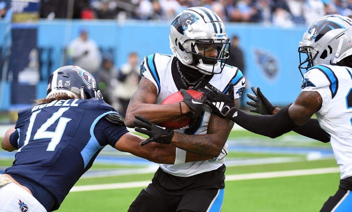 Nov 26, 2023; Nashville, Tennessee, USA; Carolina Panthers wide receiver Ihmir Smith-Marsette (11) is tackled by Tennessee Titans wide receiver Colton Dowell (14) on a punt return during the first half at Nissan Stadium.