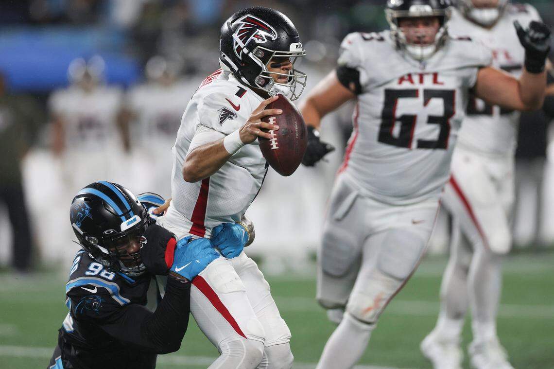 Carolina Panthers defensive end Marquis Haynes Sr., left, grabs onto Atlanta Falcons quarterback Marcus Mariota for his second consecutive sack on Thursday, November 10, 2022.