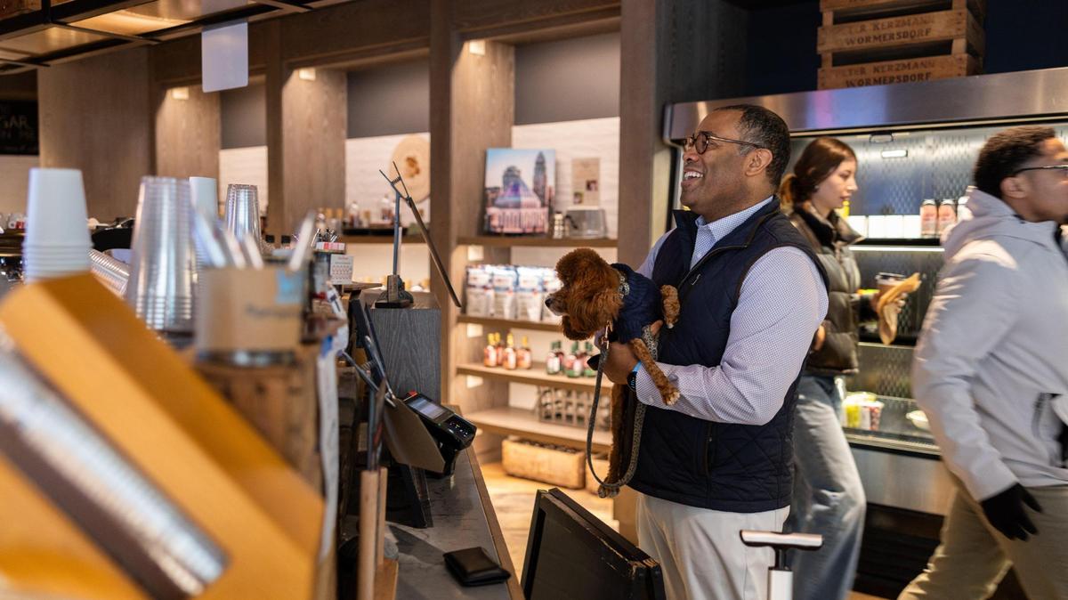 Benjamin Bowman gets a drink at Coco and the Director with his service dog, Posh, in Charlotte, N.C., on Wednesday, January 16, 2025.