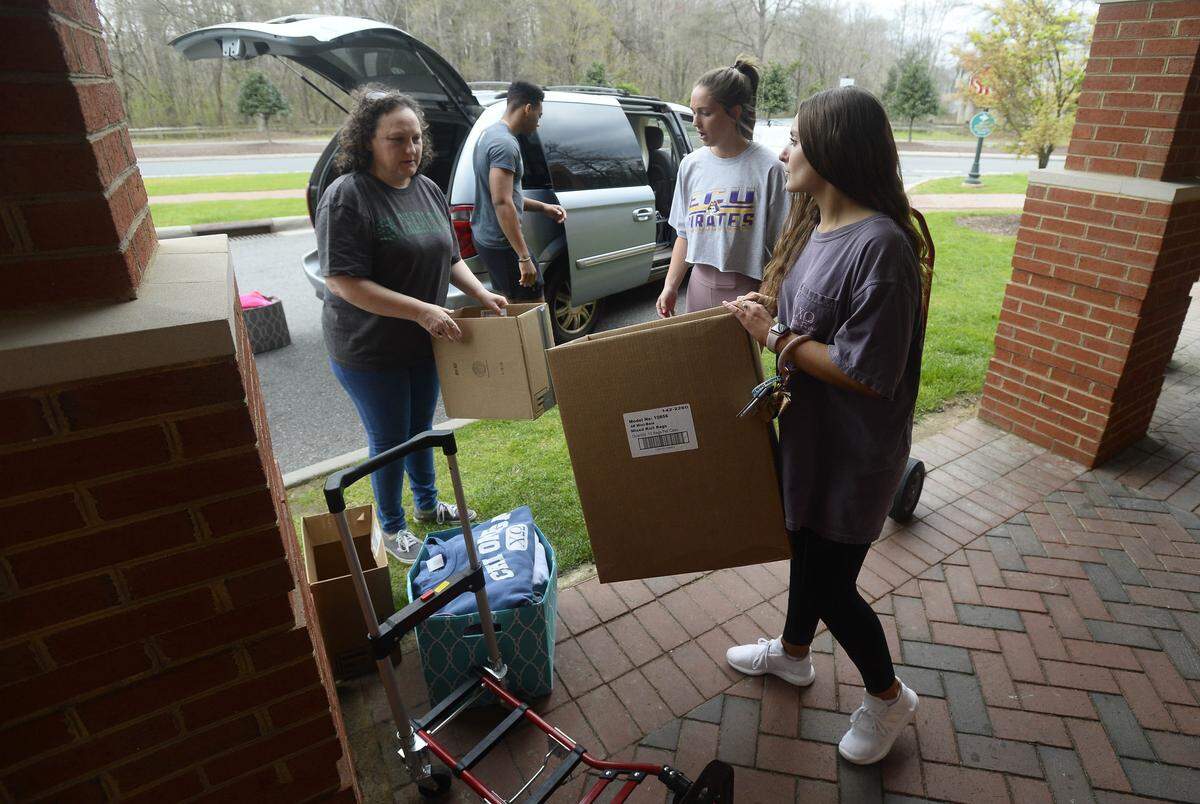 UNC Charlotte student Lauren Dickerson, right, from Bahama, NC takes a box from Robin Hicks-Dickerson, as she packs and loads items to leave the university on Wednesday, March 18, 2020. UNC Charlotte is requiring all students living on campus to leave residence halls by 5 p.m. Friday due to the coronoavirus health concerns.