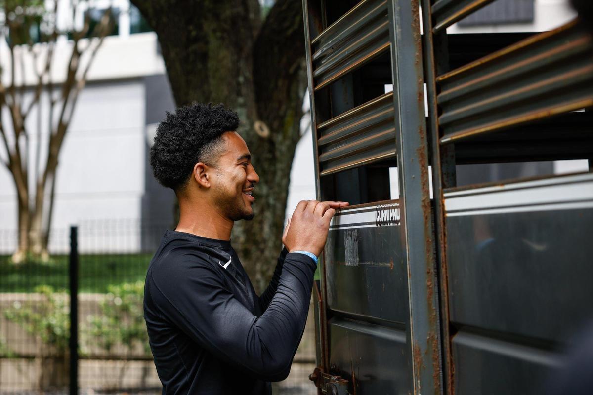 Panthers quarterback Bryce Young smiles as he looks in on the goats brought in Monday by Zen Hooves for goat yoga at Bank of America Stadium. The Panthers brought in the goats as part of mental health awareness month.