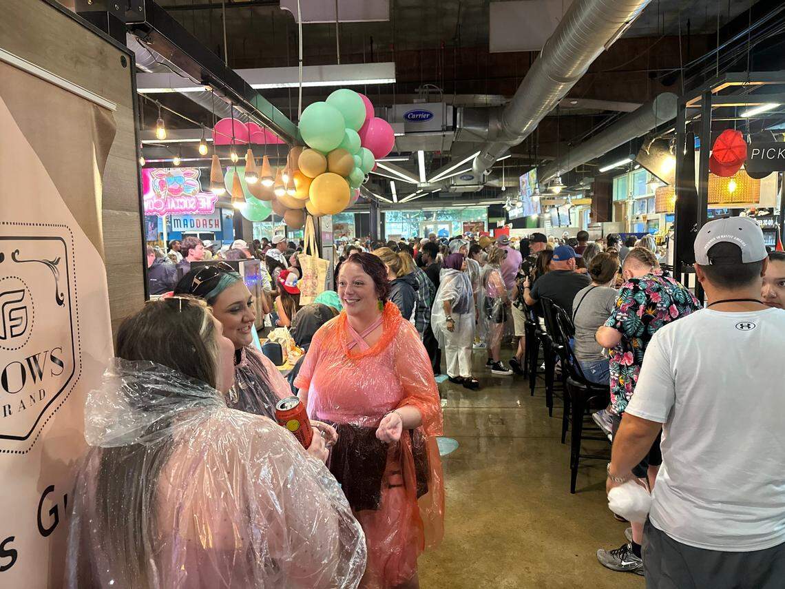 Festivalgoers in rain ponchos mingle about the crowds at The Market at 7th Street after Lovin’ Life Music Festival was evacuated on Saturday, May 3.